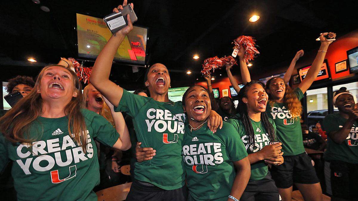 University of Miami basketball players Adrienne Motley and Jessica Thomas, center, celebrate with their teamamtes on Monday, March 13, 2017 as they realize they will be playing at home in the NCAA women’s basketball tournament. (Patrick Farrell/Miami Herald/TNS)