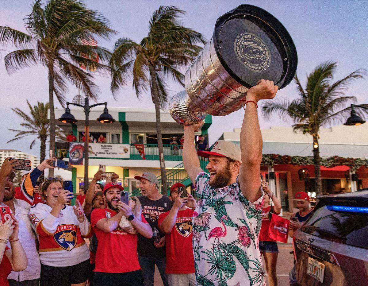 Panthers Captain Aleksander Barkov raises the Stanley Cup outside the Elbo Room in Fort Lauderdale before sunrise the day after the Florida Panthers won the Stanley Cup Final for the second time on Wednesday, June 18, 2025.