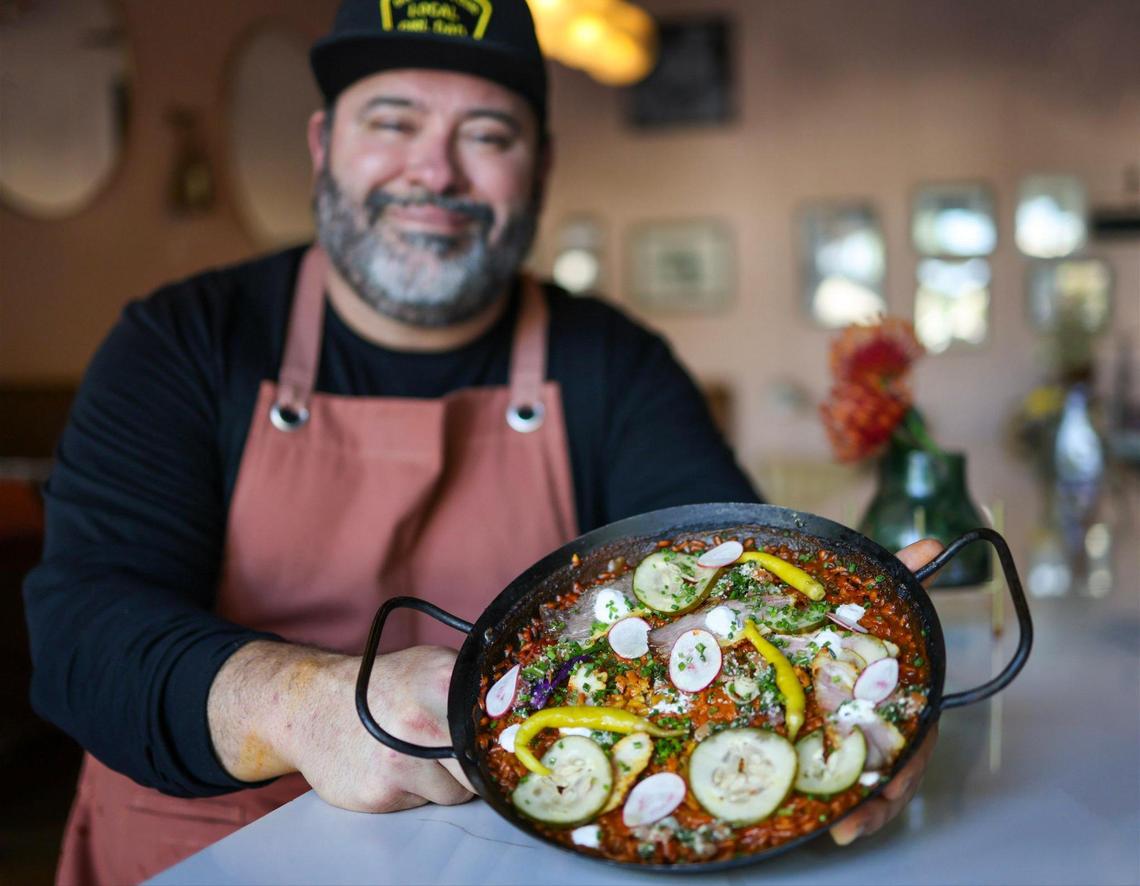 Jorgie Ramos holds a pan of smoked paella at his South Miami restaurant Bar Bella.