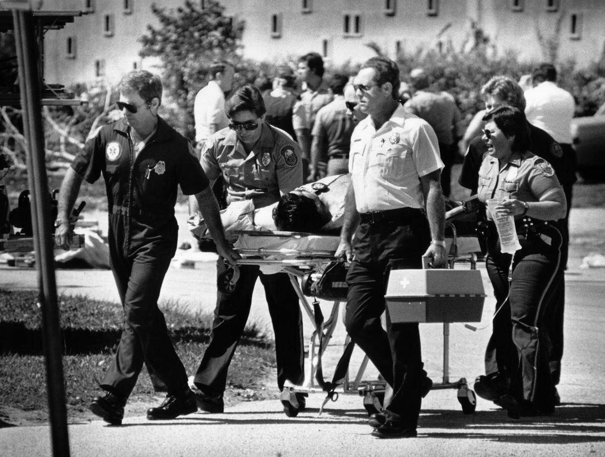 A shooting victim is taken by rescue personnel in Suniland after a shootout in which two FBI agents were killed.