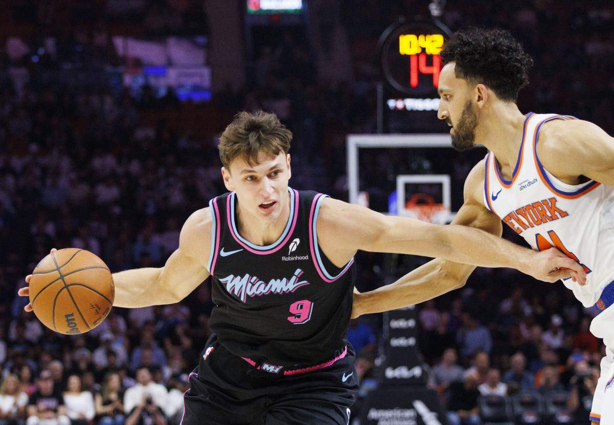 Miami Heat guard Pelle Larsson (9) dribbles around New York Knicks guard Landry Shamet (44) during the first half of a game on Nov. 17, 2025, at Kaseya Center in Miami.
