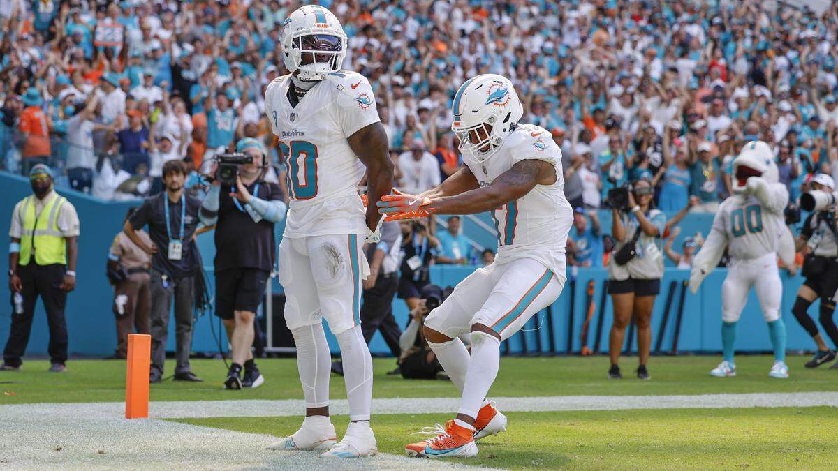 Miami Dolphins wide receiver Tyreek Hill (10) holds his hands behind his back as if he is handcuffed as Miami Dolphins wide receiver Jaylen Waddle (17) unlocks them after Hill scores in the second half during an NFL football game at Hard Rock Stadium in Miami Gardens, Florida, on Sunday, September 8, 2024.