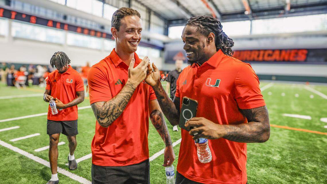 Miami Hurricanes quarterback Carson Beck and running back Mark Fletcher Jr. greet each other during media day at the Carol Soffer Indoor Practice Facility in Coral Gables, Florida, on Wednesday, July 30, 2025. 