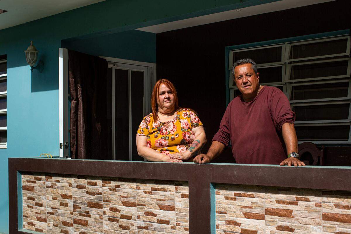 Elba Santos and David González, parents of Angie González, stand outside their house in Barranquitas, Puerto Rico, on March 21, 2021.
