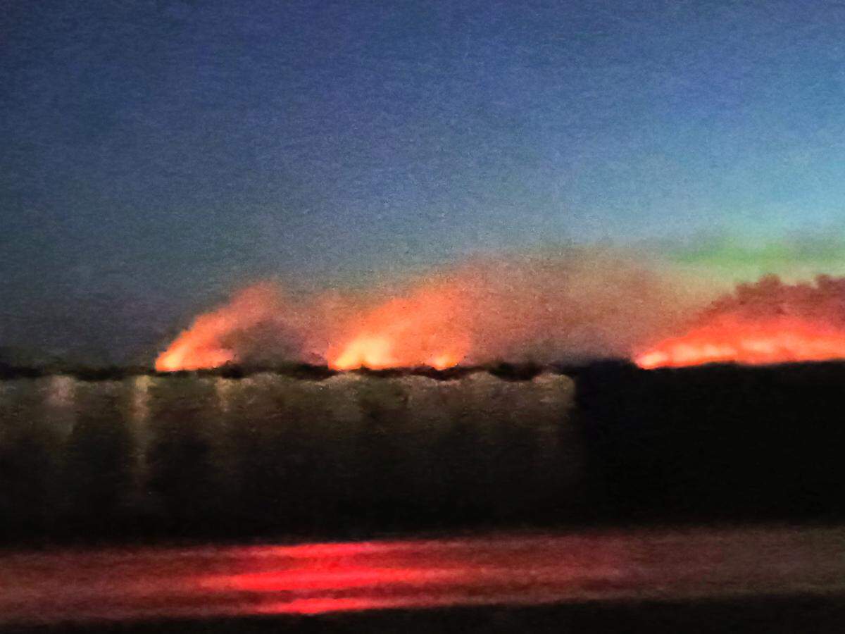Large flames from the Mile Marker 39 fire in the Everglades can be seen while driving down Alligator Alley early Thursday morning, Aug. 21, 2025.