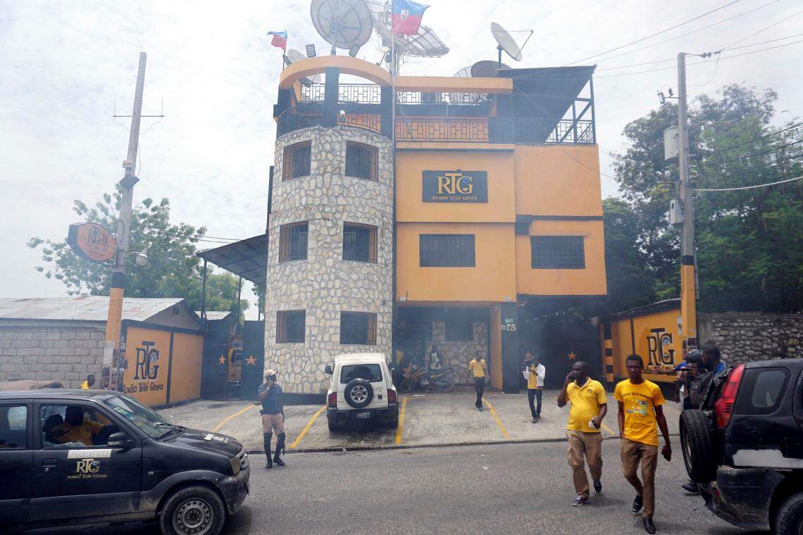 Journalists and staff walk outside of Radio Télé Ginen after it was vandalized during a protest demanding the resignation of President Jovenel Moise in Port-au-Prince, Haiti, Monday, June 10, 2019.