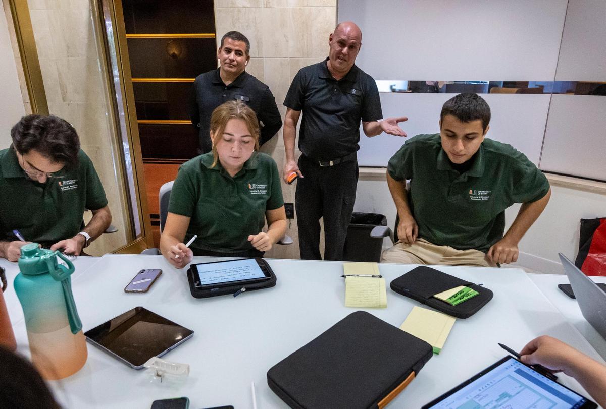 Building engineer Isel Morfa, center right, answers questions about 550 Biltmore Way during a preliminary meeting with auditors from the University of Miami Industrial Assessment Center.