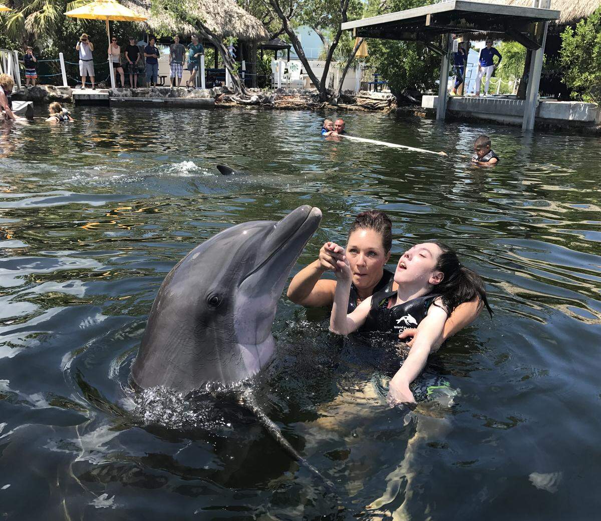 Island Dolphin Care assisted-animal therapist Danielle Smalling holds Ashtyn Montali, 15, from Boynton Beach, at the Key Largo marine mammal facility on Wednesday, June 5, 2019.