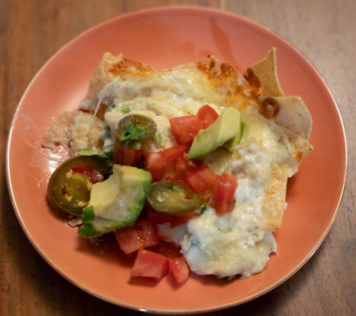 Crab nachos plated on a red dish.