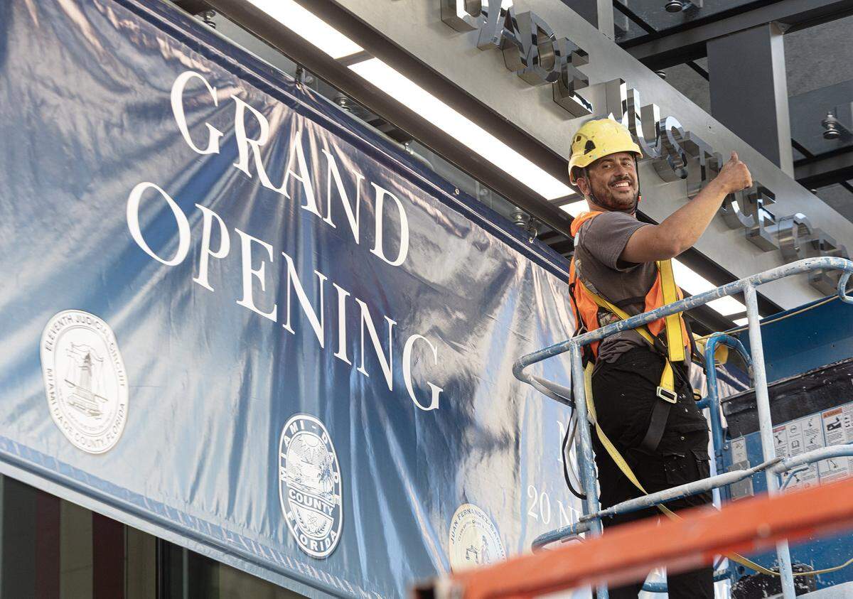 Miami, November 7, 2025 - Kevin Toro puts up the “Grand Opening” sign in preparation for the ribbon cutting that will take place on Monday, November 10, 2025. Miami-Dade opens its new civil courthouse, the Osvaldo N. Soto Miami-Dade Justice Center that will replace the historic courthouse next door on Flagler Street