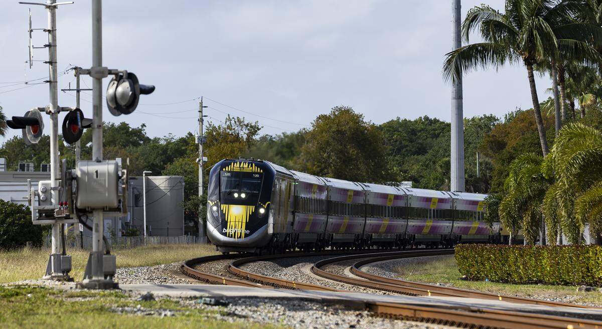 A Brightline train makes its way toward Northeast 141 Street near Biscayne Boulevard in North Miami, Florida.