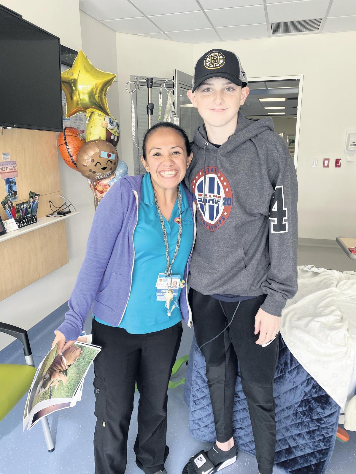 Cole Vaccarella with Ellie Fitzgibbons, a child-life specialist on the cancer floor at Nicklaus Children’s Hospital. Cole, a sophomore at St. Thomas Aquinas, was diagnosed with osteosarcoma in January.