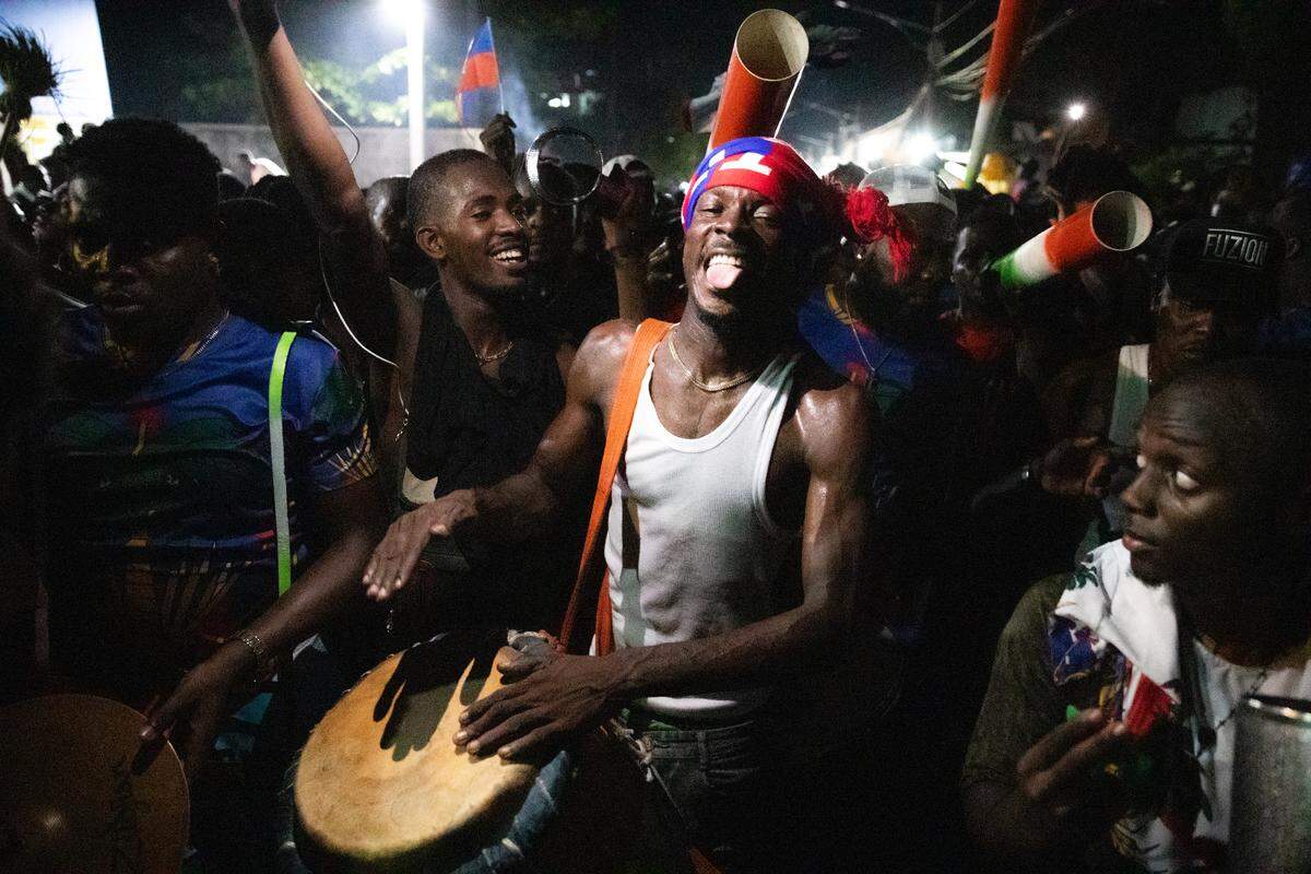 TOPSHOT - Fans cheer in the streets of Port-au-Prince on November 18, 2025 as Haiti celebrates its victory over Nicaragua and qualification for the 2026 FIFA World Cup. Haiti, who last appeared in the World Cup in 1974, completed an improbable qualification campaign with a 2-0 win over Nicaragua. Ironically, Haiti secured their decisive qualification victory in Curacao, where the team have been forced to play their home qualifiers due to unrest in their homeland. (Photo by Clarens SIFFROY / AFP) (Photo by CLARENS SIFFROY/AFP via Getty Images)