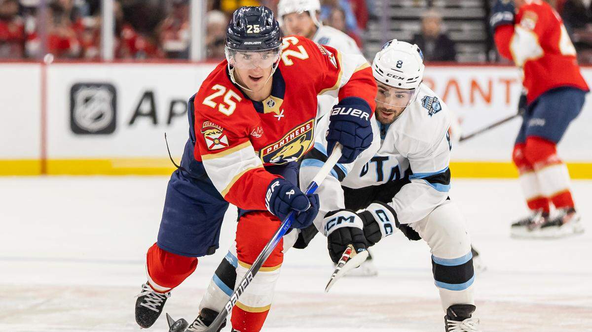 Florida Panthers right wing Mackie Samoskevich (25) skates with the puck as Utah Hockey Club center Nick Schmaltz (8) defends in the first period of their NHL game at Amerant Bank Arena on Friday, March 28, 2025, in Sunrise, Fla.