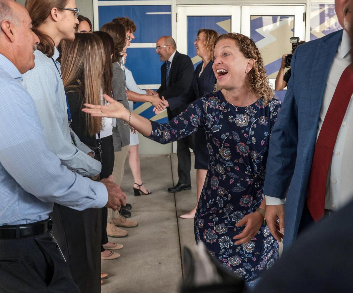 U.S. Secretary of Education Miguel Cardona, right, and U.S. Rep. Debbie Wasserman Schultz are greeted by students and staff members on Monday, April 4, 2022, as they tour Cypress Bay High School in Weston, Florida, where they learned more about the school’s career development programs, including the FBI Cyber Stem Academy.