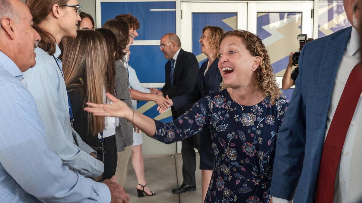 U.S. Rep. Debbie Wasserman Schultz, center, is greeted by students and staff members as she and U.S. Secretary of Education Miguel Cardona toured Cypress Bay High School in Weston, Florida, on Monday, April 4, 2022. The next day she tested positive for COVID-19. Cardona tested negative.