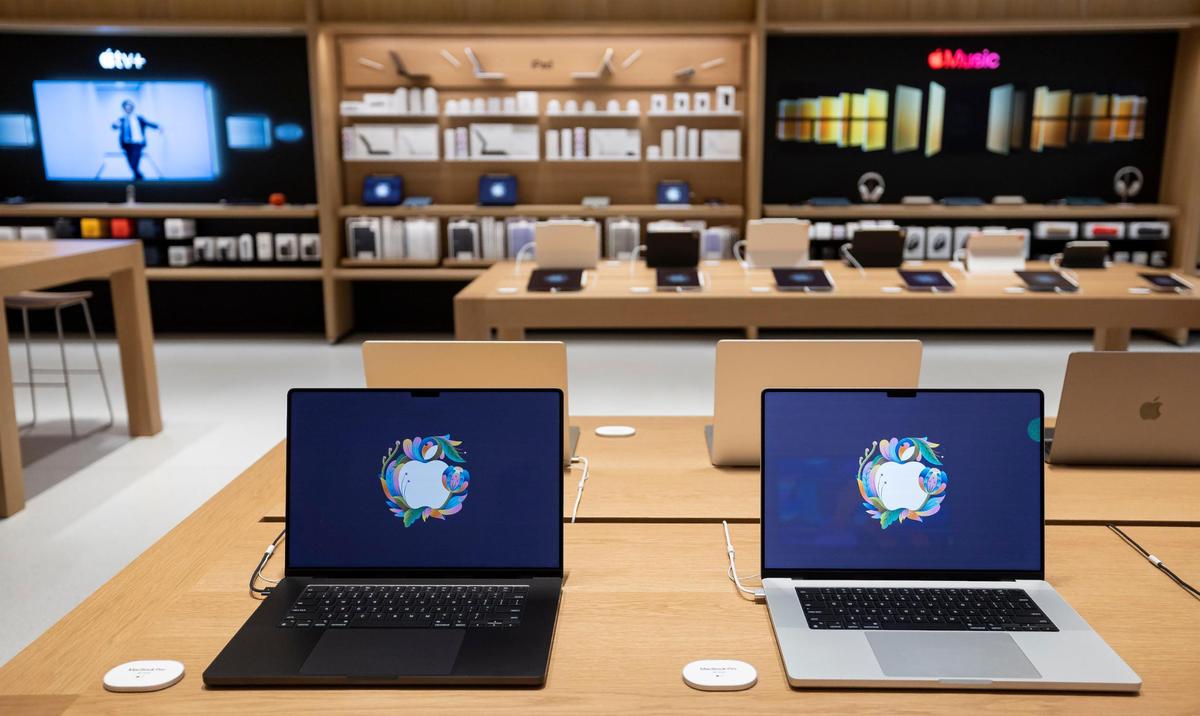 MacBook Pros are on display inside the new Apple Miami Worldcenter store during a media preview on Wednesday, Jan. 22, 2025, in downtown Miami, Fla. Apple is set to open its newest store in downtown Miami on Friday, featuring a dedicated pickup area and a biophilic garden.
