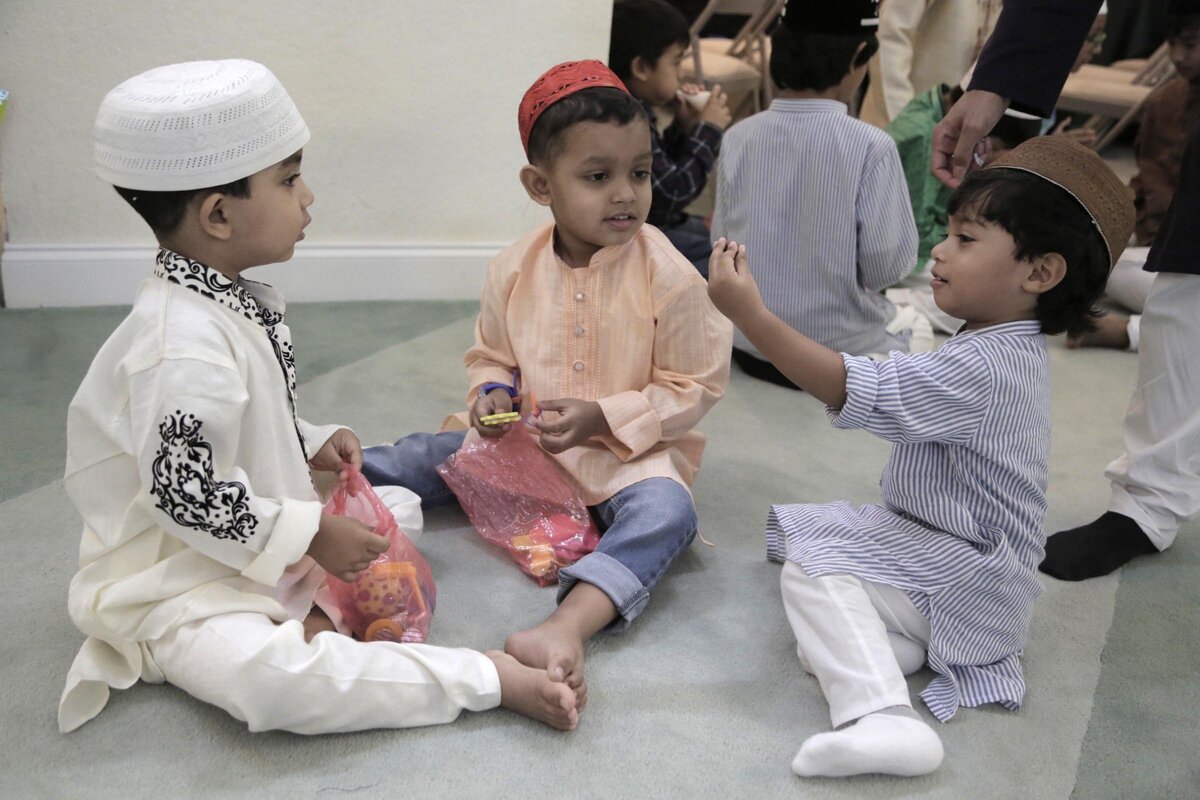 Faris Ahmed, Talha Ahmed and Zying Budan enjoy gifts given to them after the prayer service at a Hallandale Beach mosque.