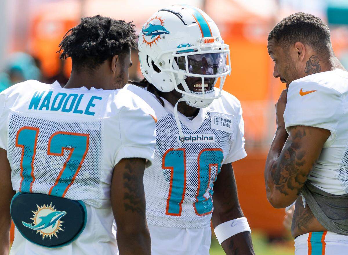 Miami Dolphins wide receivers Jaylen Waddle (17), Tyreek Hill (10) and Freddie Swain (88) talk during team practice at the Baptist Health Training Complex on Friday, Aug. 4, 2023 in Miami Gardens, Fla.