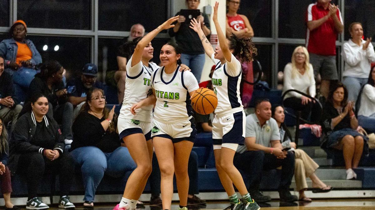 SLAM guards Adaya Montalvo (2) and Samantha Bajista (0) celebrate after defeating Cardinal Gibbons during the girls basketball regional semifinal playoff game on Tuesday, February 18, 2025, in Miami, Florida.