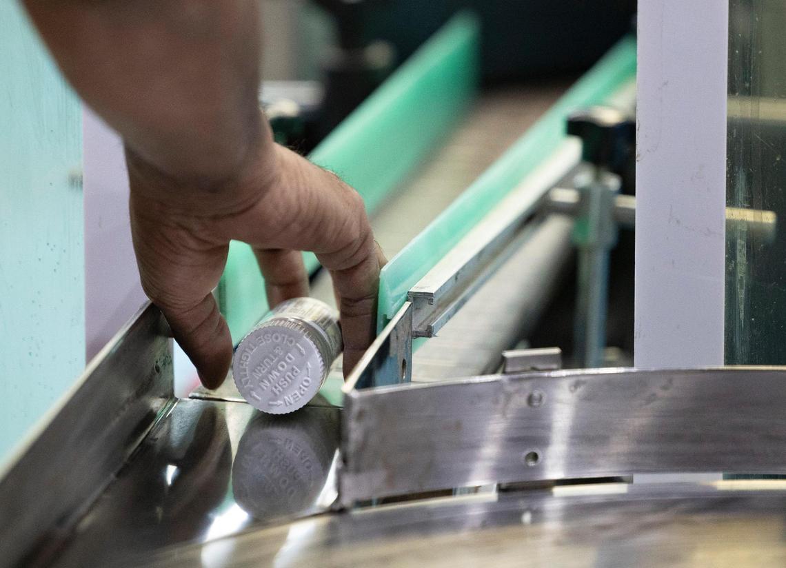 A line worker inspects every bottle for legible expiration dates and seals in the PharmaCenter packing warehouse on Tuesday, March 19, 2024, in Davie, Florida.