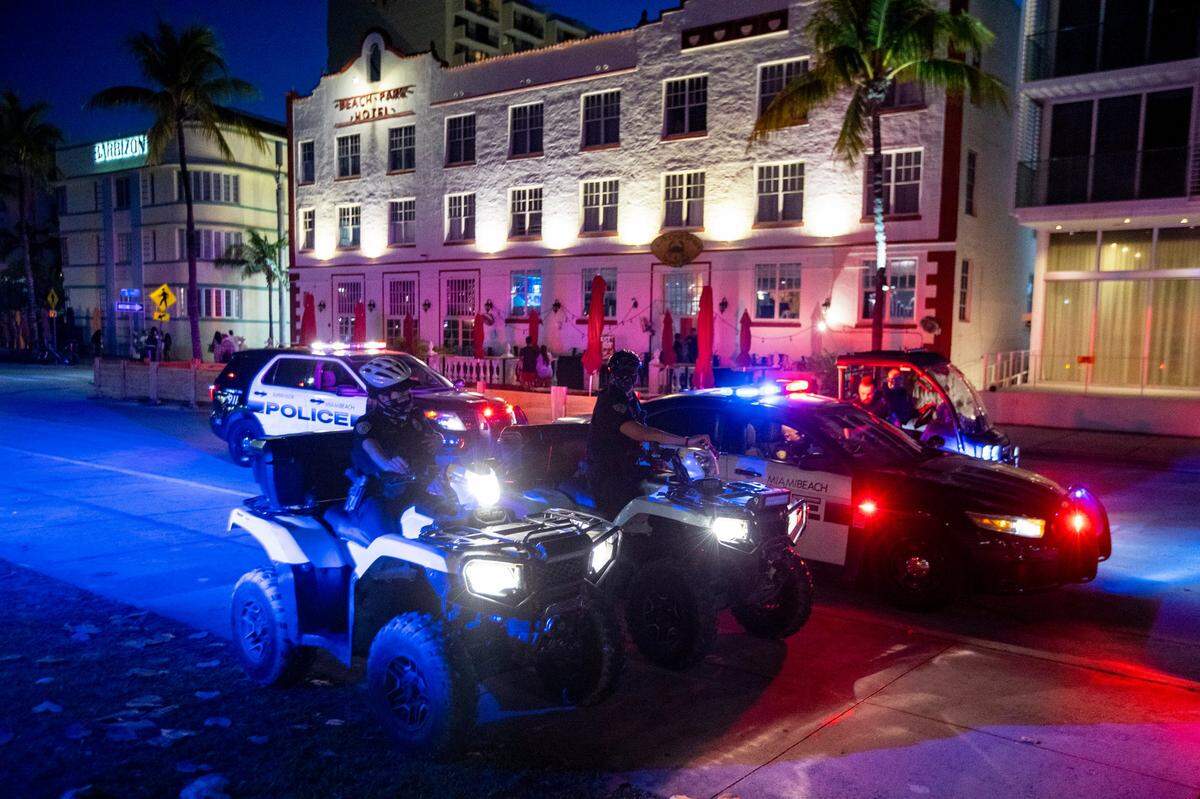 Miami Beach police officers prepare to clear Ocean Drive of crowds after curfew during spring break in South Beach on Sunday, March 28, 2021.