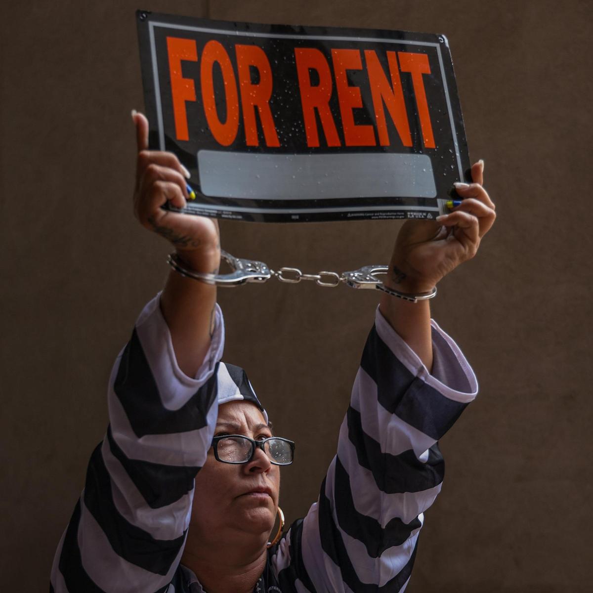 Lily Vásquez, de la organización sin fines de lucro WYN Women, es fotografiada esposada y con un disfraz de presa en protesta por los altos alquileres y la falta de viviendas asequibles. Los activistas a favor de la vivienda justa de Miami Coalition to Advance Racial Equity, Struggle for Miami's Affordable and Sustainable Housing (SMASH), y otros se manifestaron en protesta por los altos alquileres y por la vivienda asequible antes de la reunión de la comisión del condado en el Ayuntamiento del Condado en el downtown de Miami, Florida, el martes 15 de marzo de 2022.