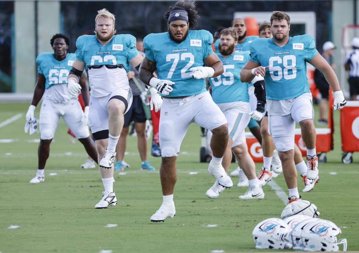 Miami Dolphins guard Jonah Savaiinaea (72) works out with teammates before an NFL football joint practice with the Jacksonville Jaguars at the Miami Dolphins Training Camp in Miami Gardens, Florida.