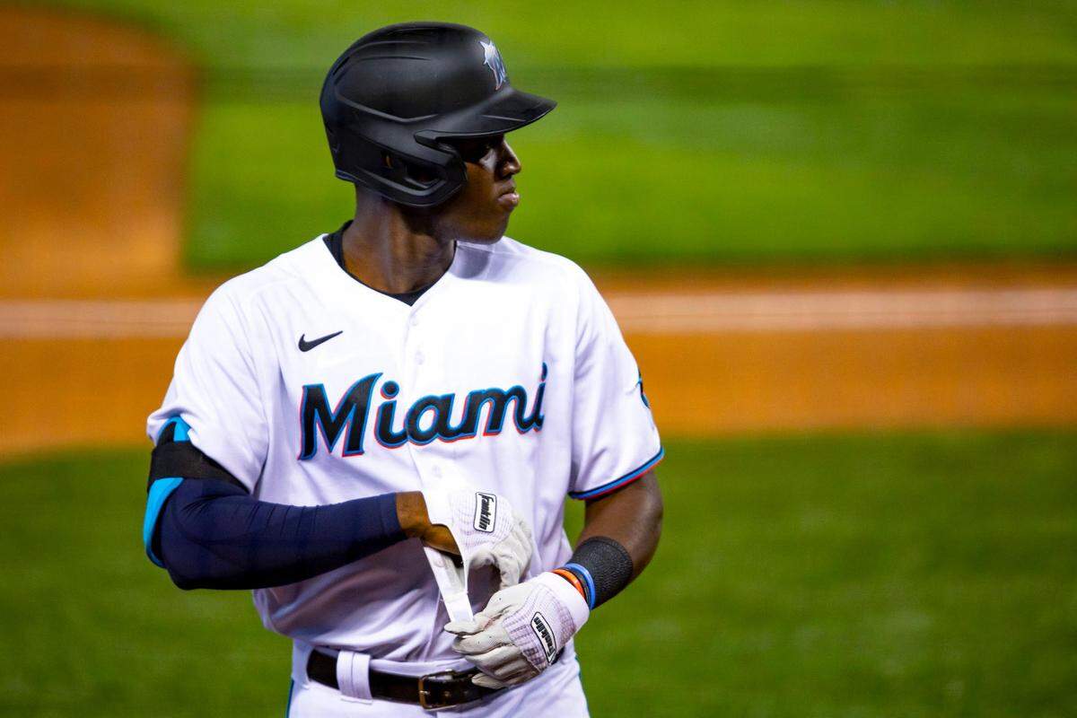 Marlins outfielder Jesus Sanchez takes off his batting gloves as he approaches the dugout after a switch of innings during a simulation game at Marlins Park in Miami, Florida on Friday, July 10, 2020.