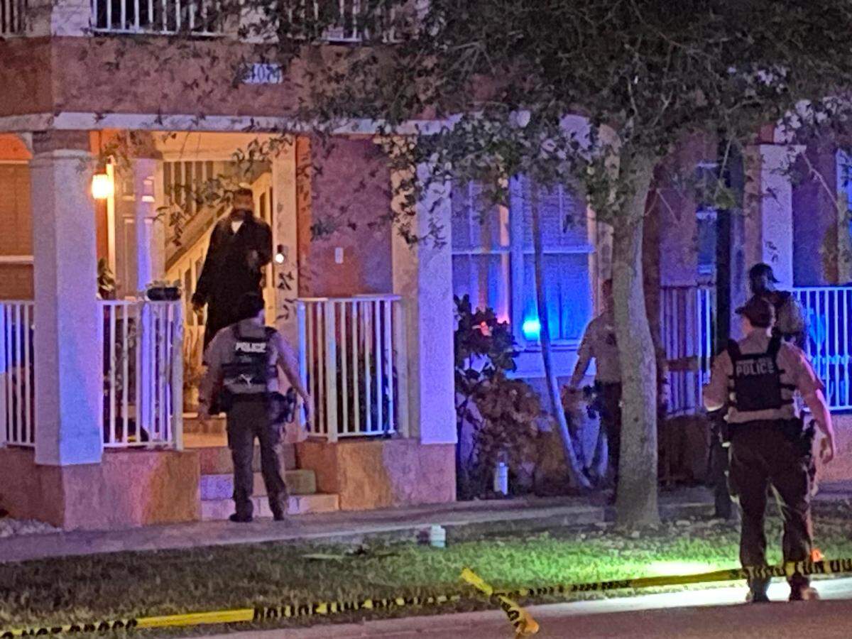 Miami-Dade County police officers investigate outside a townhouse at SW 109th Avenue and 240th Street Saturday, Oct. 20, 2024. Multiple shots were fired outside the home