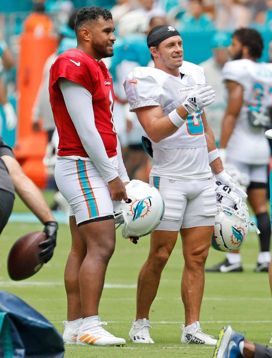 Miami Dolphins quarterback Tua Tagovailoa (1) and wide receiver Braxton Berrios (0) interact during team drills at Hard Rock Stadium in Miami Gardens on Saturday, August 5, 2023.