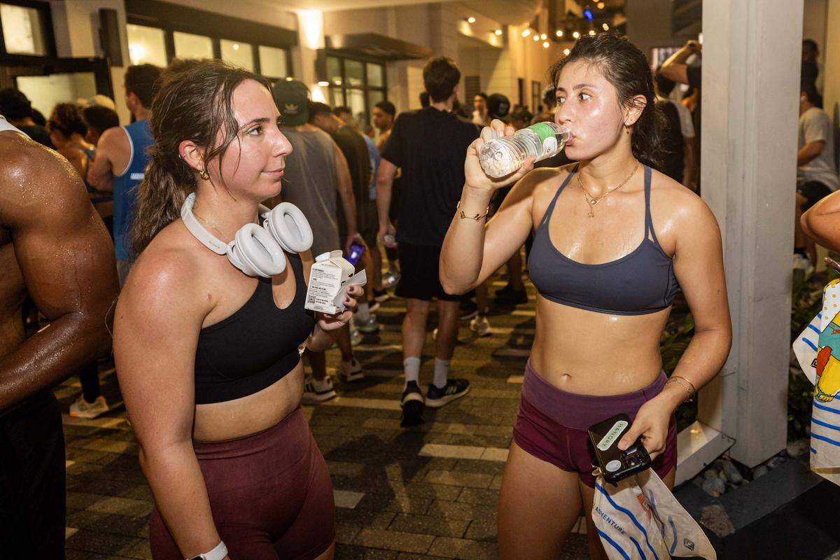 Members of the Brickell Run Club rest and drink water after a run on Tuesday, September 3, 2025, in Miami, Fla.