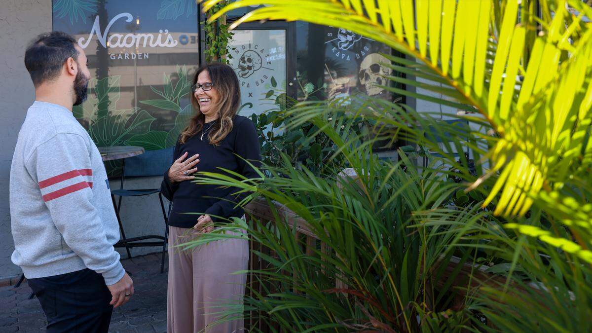 Omaar, left, chats with his mother Shula Yemeni, right, while waiting for an Uber at Naomi's Garden new Miami Beach location on Tuesday, January 27, 2026.