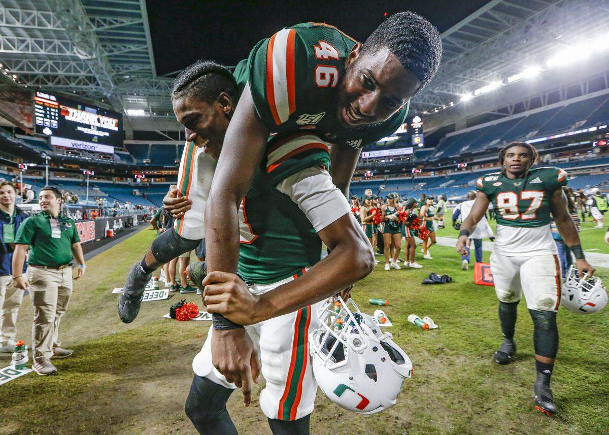 Miami Hurricanes wide receiver Evidence Njoku (83) carries tight end Nicholas Ducheine (46) off the field after the Hurricanes defeat the Louisville Cardinals 52-27 on Saturday, November 9, 2019.