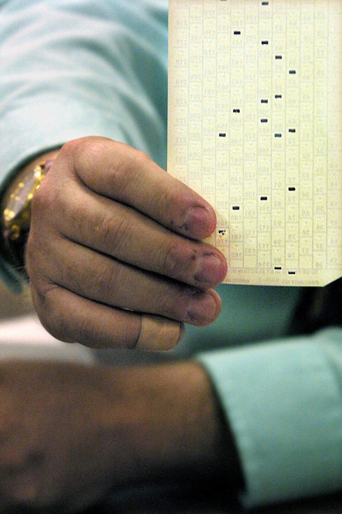 A Broward County Supervisor of Elections Office staff member holds up a lballot cast Nov. 7, 2000.