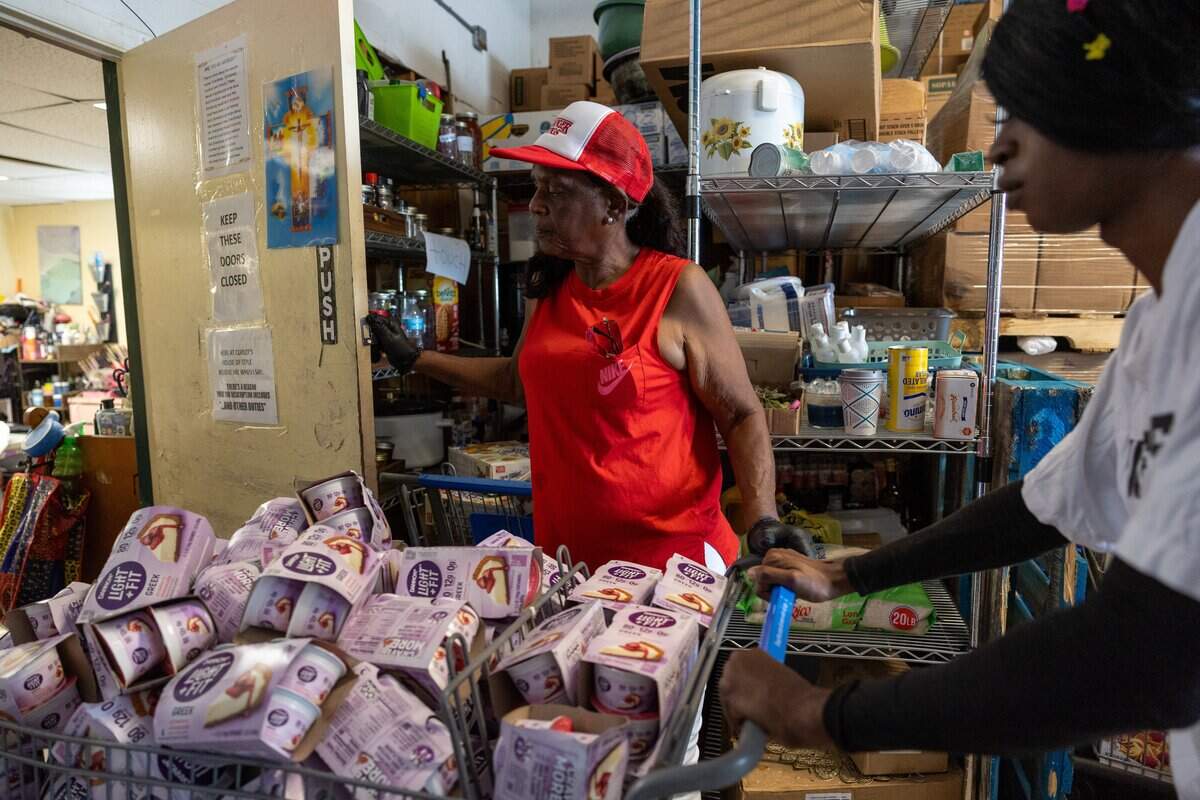 Volunteers Dorothy Blunt, left, and Kamausi Reynolds, right, push carts loaded with food to be distributed at Curley's House Food Bank in Miami on Thursday, June 4, 2026.