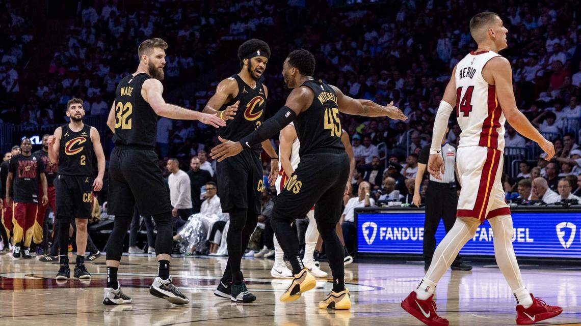 Cleveland Cavaliers guard Donovan Mitchell (45) reacts with center Jarrett Allen (31) and forward Dean Wade (32) after scoring as Miami Heat guard Tyler Herro (14) walks towards the bench during the first half of Game 4 of the Eastern Conference NBA Playoffs at Kaseya Center on Monday, April 28, 2025, in Miami, Fla.