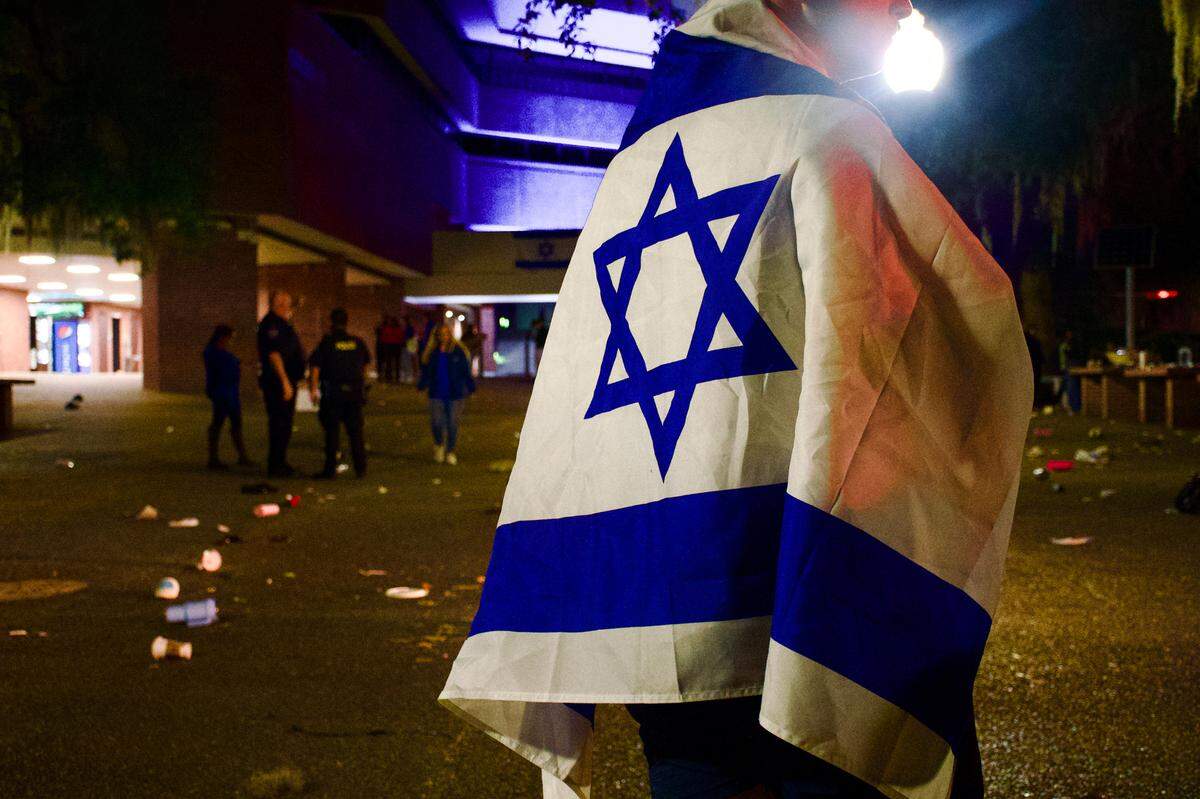 A student stands over in an emptied Turlington Plaza Monday night, Oct. 9, 2023 after a scare caused hundreds of students to run from a candle vigil supporting Israel following the Hamas attacks. (Augustus Hoff/WUFT News)