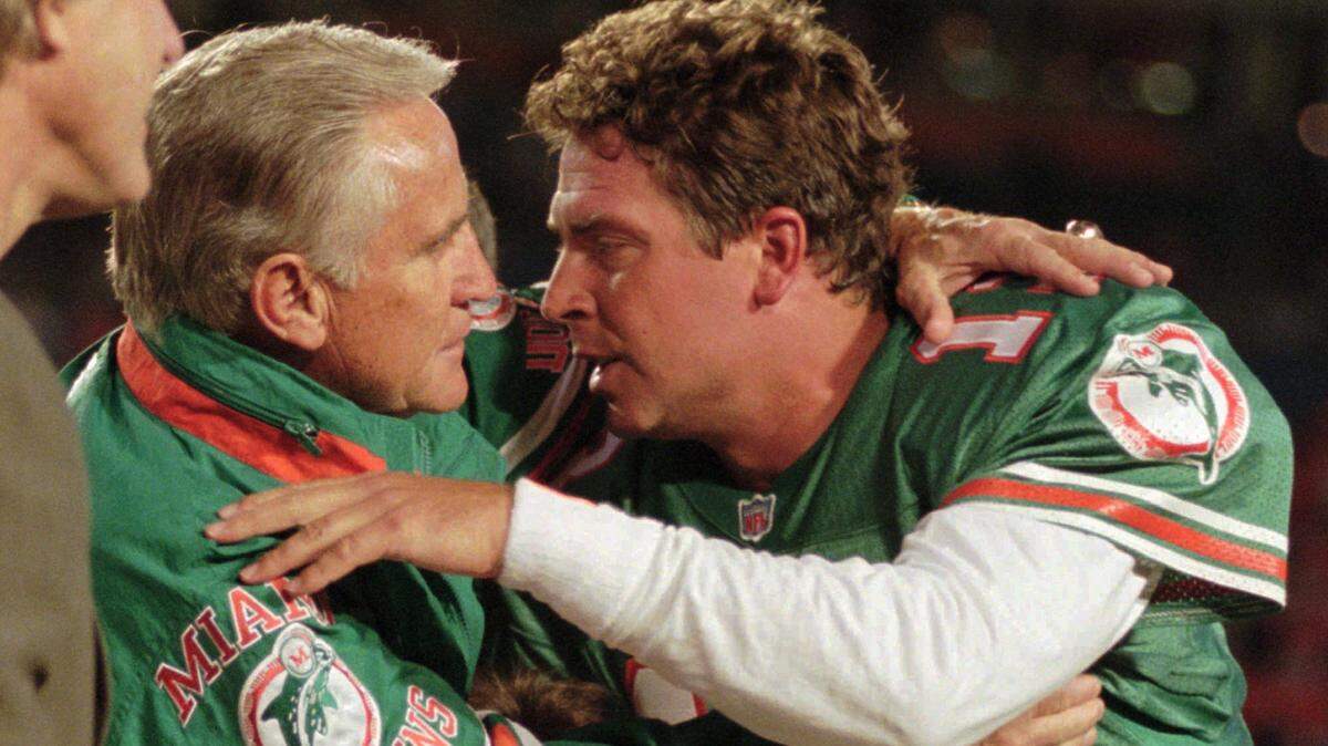 Miami Dolphins’ coach Don Shula, left, gives Dolphins quarterback Dan Marino a congratulatory hug as Marino was honored Monday night, Dec. 11, 1995 for breaking three standing passing records previously held by Minnesota Vikings quarterback Fran Tarkenton.