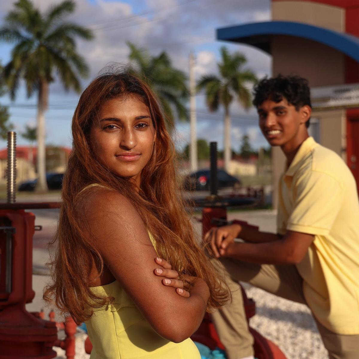 Brother and sister, Ava, left, and Joshua Martoma, right, stand across the street of the Federal Correction Institution Miami where their father was once incarcerated. As kids, they would visit their father every weekend in prison.