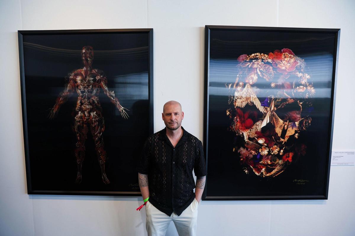 Artist Gary James McQueen is photographed alongside his work “The Flayed Angel,” left, and “Savage Beauty” during Art Miami 2023 on Tuesday, Dec. 5, 2023, in downtown Miami, Fla.