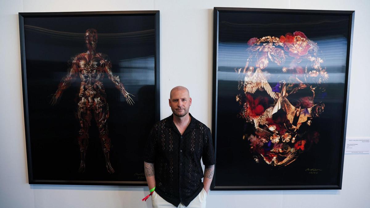 El artista Gary James McQueen es fotografiado junto a sus obras 'The Flayed Angel', izquierda, y 'Savage Beauty' durante Art Miami 2023, el martes 5 de diciembre de 2023, en el downtown de Miami, Florida.