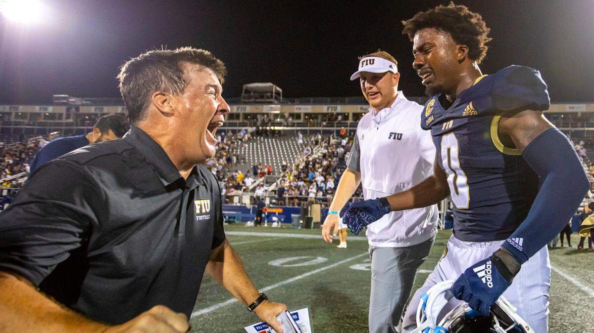 Florida International University Head Coach Mike MacIntyre reacts with wide receiver Tyrese Chambers (0) after defeating Bryant University 38-37 in overtime of an NCAA Conference USA football game at Riccardo Silva Stadium in Miami, Florida, on Thursday, September 1, 2022.