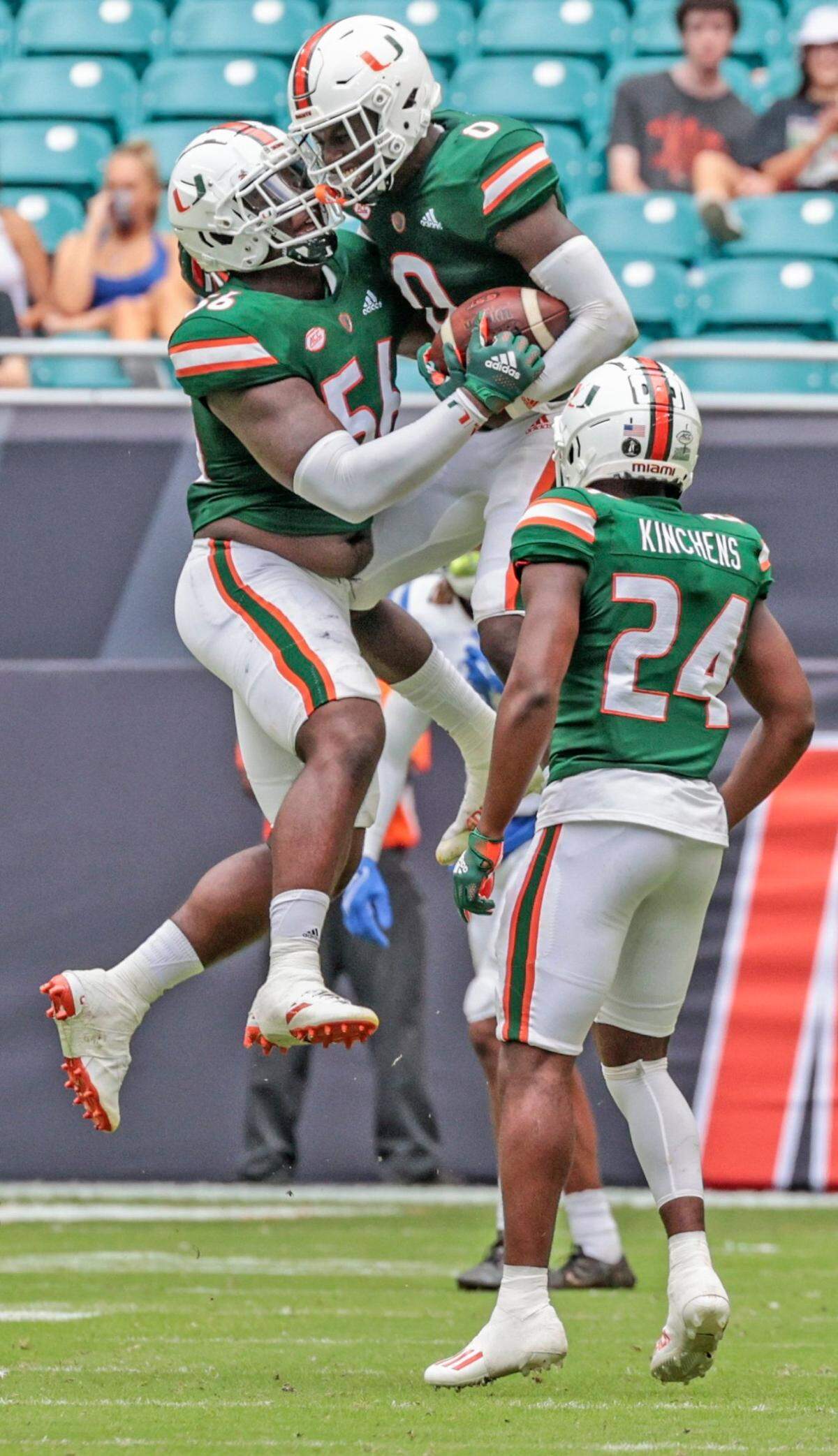 Miami Hurricanes safety James Williams (0) and Miami Hurricanes defensive lineman Leonard Taylor (56) celebrate after Williams intercepts the ball in the fourth quarter during game against Central Connecticut State Blue Devils at Hard Rock Stadium in Miami Gardens on Saturday, September 25, 2021.