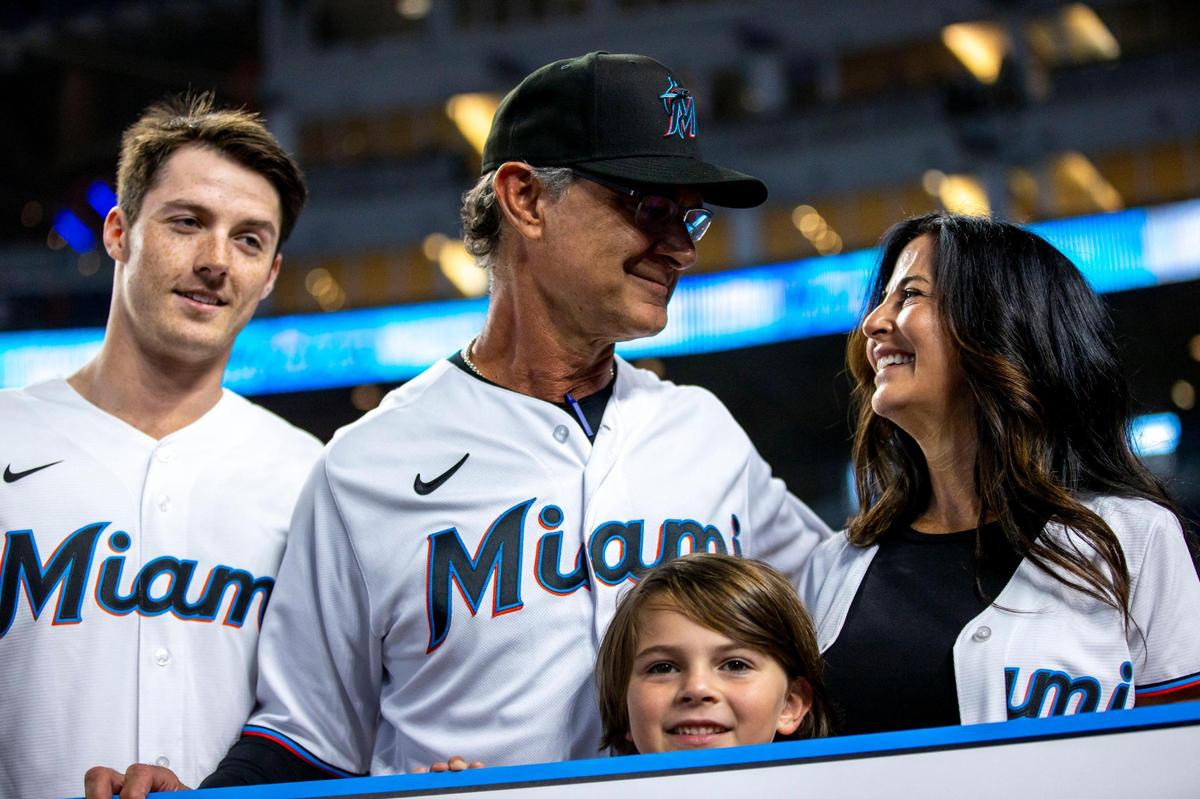 Miami Marlins manager Don Mattingly, center, Lori Mattingly, far right, Louis Riley Mattingly, bottom center, Isaac Manion, left, react to receiving a donation to Mattingly Charities by the Marlins organization during his final MLB game at loanDepot park in the Little Havana neighborhood of Miami, Florida, on Wednesday, October 5, 2022.