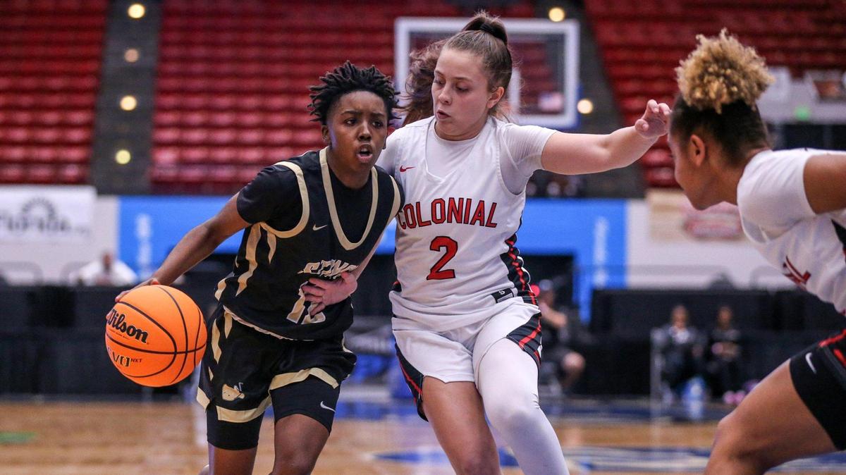 Miami High’s Janay Quinn (12) drives the ball as Colonial’s Sophya Barreiro (2) defends in a Class 7A girls basketball state semifinal at the RP Funding Center in Lakeland on Friday, February 25, 2022.