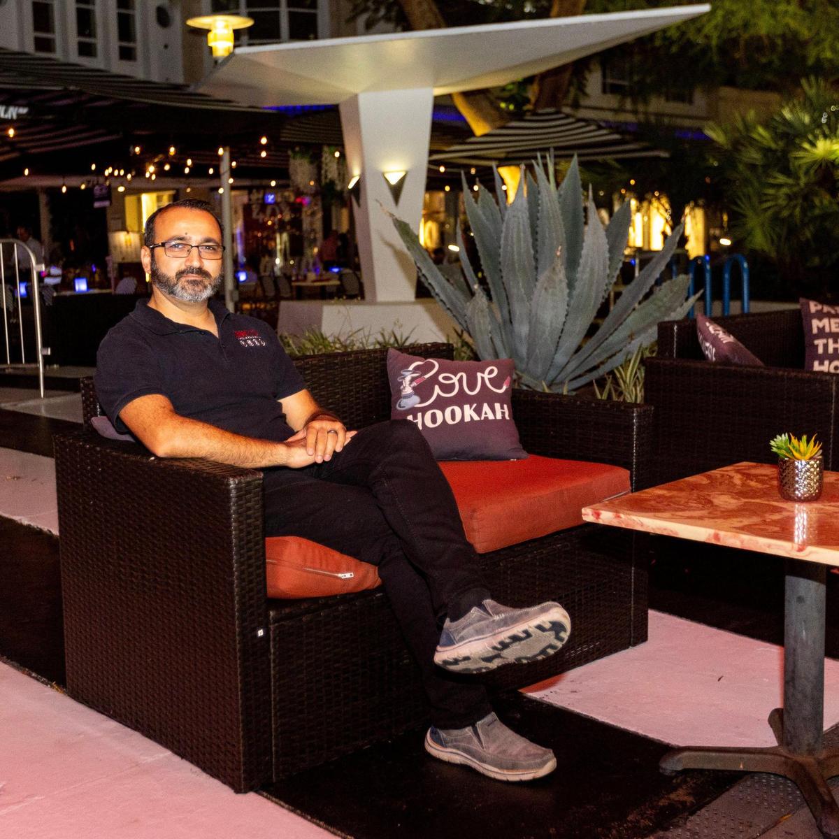 Owner Erdem Aynali sits at a table outside Groovy’s Hookah Bar on Lincoln Road on Dec. 1, 2022.