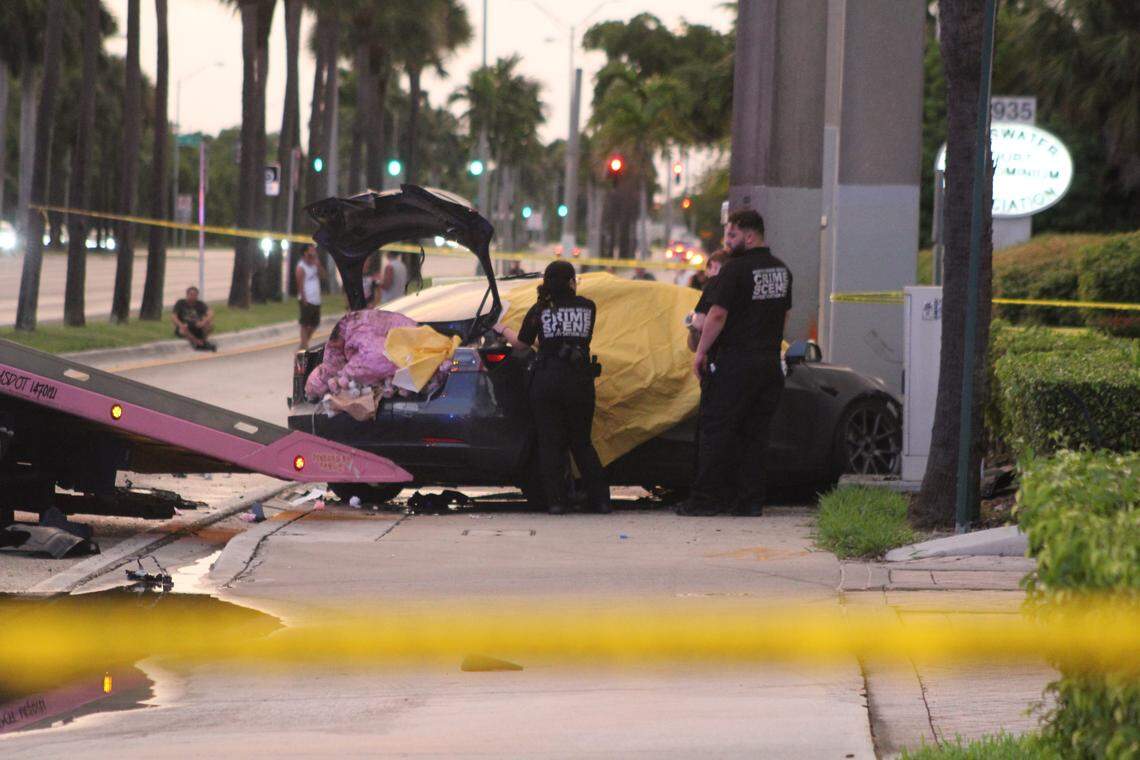 Crime scene investigators stand near a Tesla sedan that crashed in North Miami Beach Wednesday, Oct. 1, 2025. One person was killed in the crash, police said.