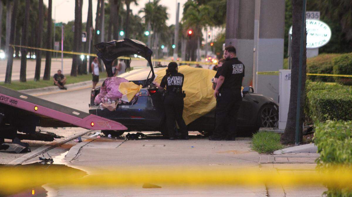 Crime scene investigators stand near a Tesla sedan that crashed in North Miami Beach Wednesday, Oct. 1, 2025. One person was killed in the crash, police said.