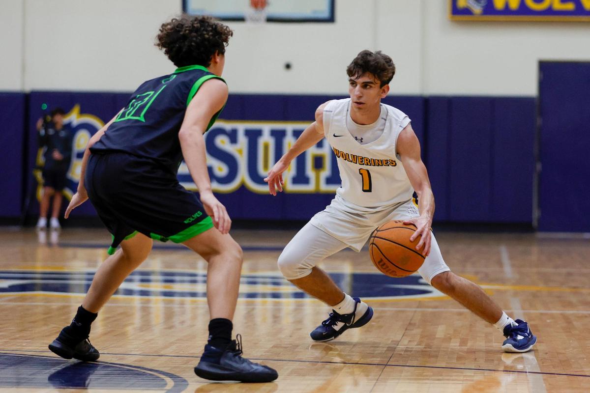Belen Jesuit guard Kevin Garcia (1) dribbles the basketball as TERRA guard Lucas Hernandez (11) defends during the second quarter of a basketball Region 4-5A quarterfinal game at Belen Jesuit Preparatory School in Miami, Florida on Thursday, February 16, 2023.
